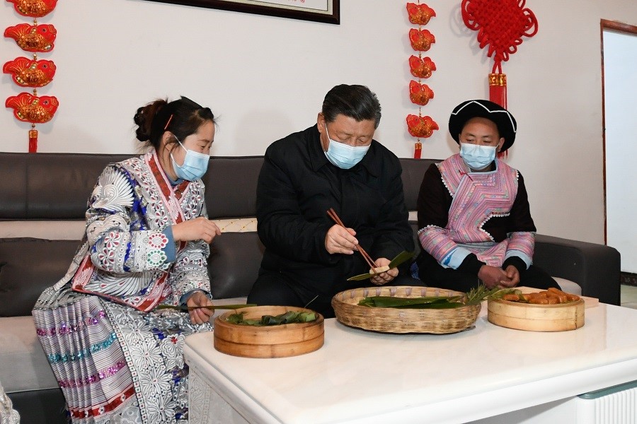 2021年2月3日下午，習近平在貴州畢節(jié)市黔西縣新仁苗族鄉(xiāng)化屋村苗族村民趙玉學家，同一家人邊聊家常邊制作當?shù)貍鹘y(tǒng)節(jié)日食品黃粑。新華社記者 李學仁 攝